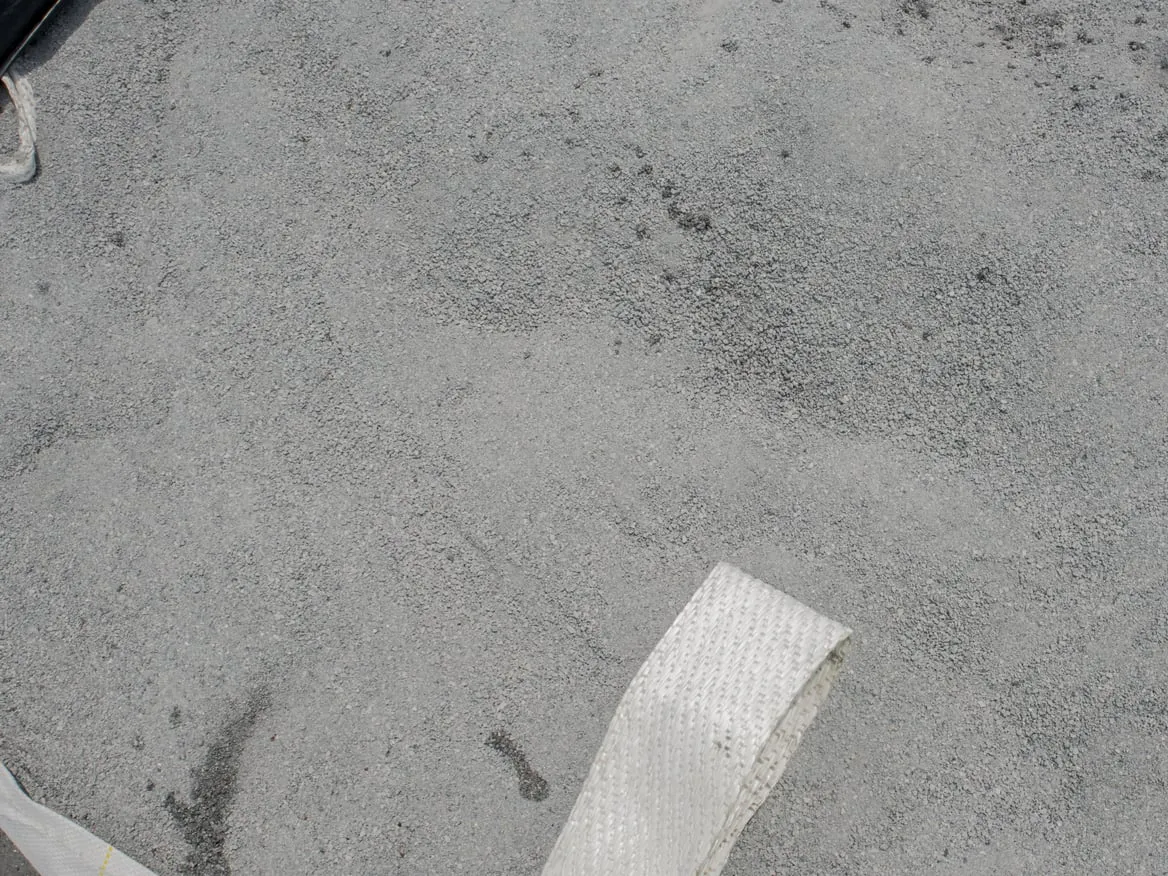Gros plan sur des granulés gris dans un grand sac, une sangle au premier plan