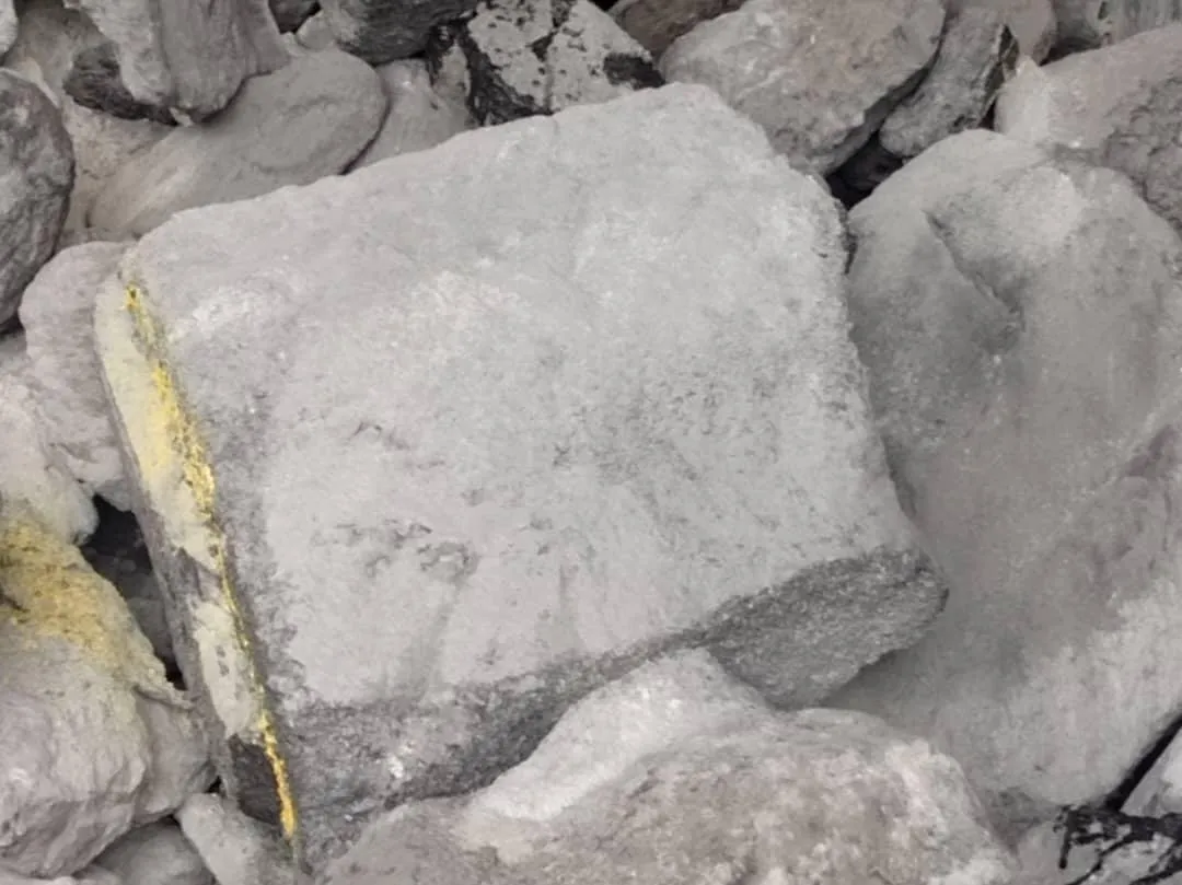 Grey spent carbon cathode blocks, with a yellow line on the middle block